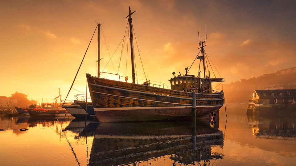 Photo of a boat in the harbour at sunset, by Steve Cole