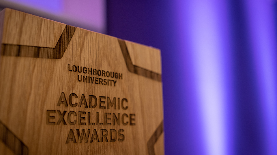 Close-up of the wooden plaques awarded to the top academic students. The plaque is engraved with a star shape containing the words 'Loughborough University Academic Excellence Awards'
