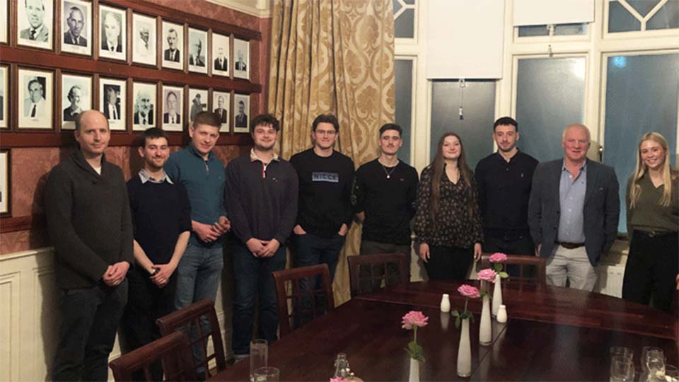 Photo of a group of students from the MA International Security at a recent field trip to Northern Ireland. They are stood together smiling towards the camera inside a room