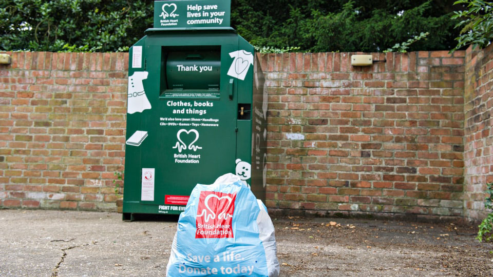 Photo of one of the outside BHF banks located on campus, with a donation bag on the floor in front of it