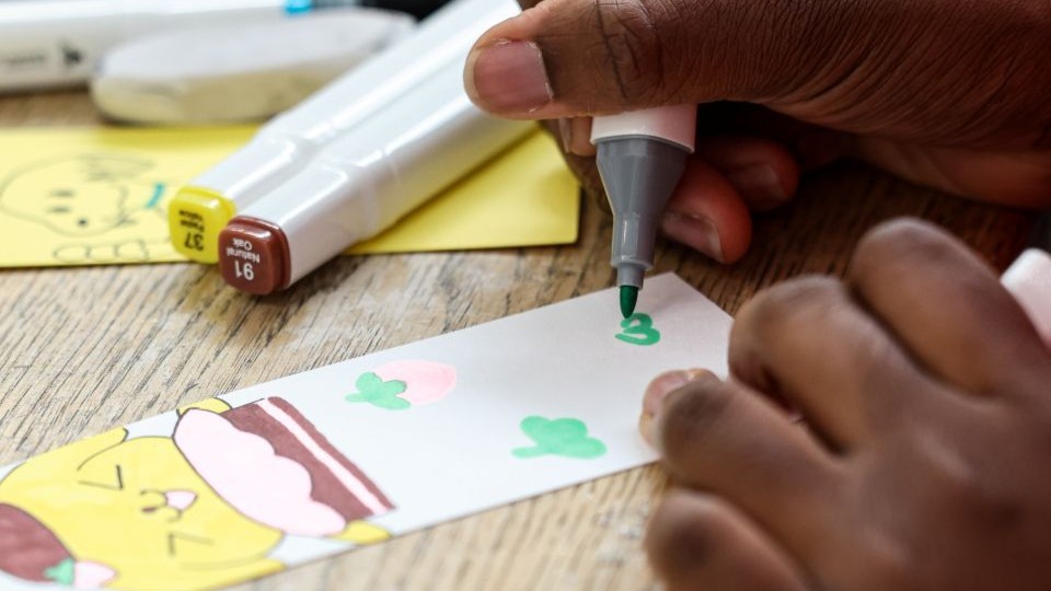 Close-up of a person colouring in a bookmark