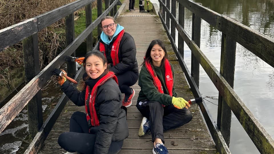 Students cleaning the canal and smiling