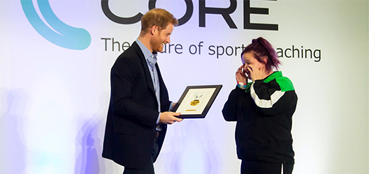 photo of Prince Harry presenting award to Coach core graduate