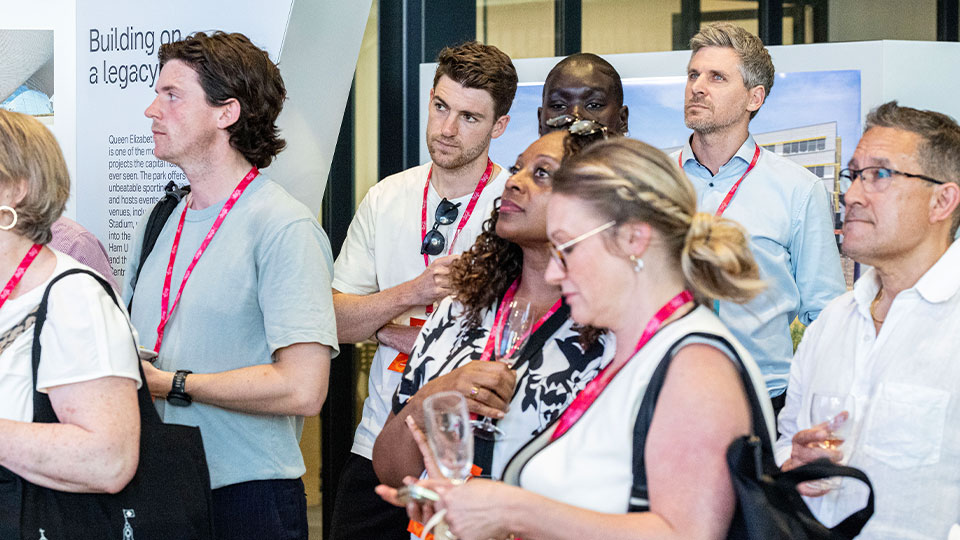 Show visitors watching a talk wearing lanyards