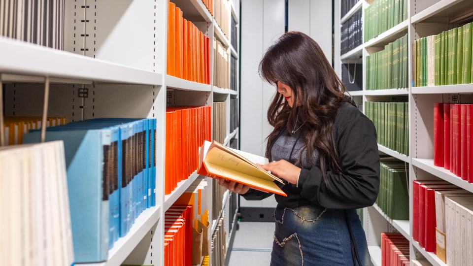 A student reading a book in the University Library.