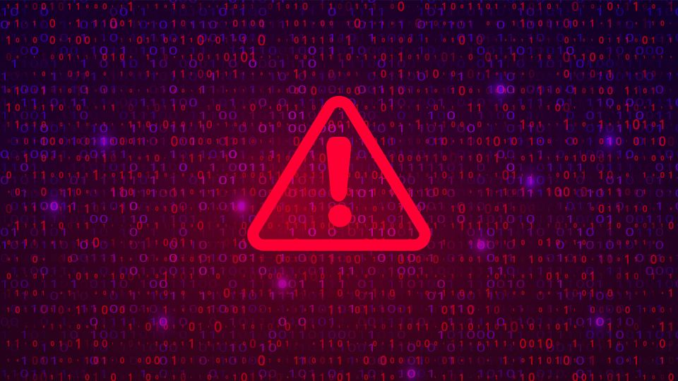 codes on a digital screen with a red triangular warning sign positioned over the top
