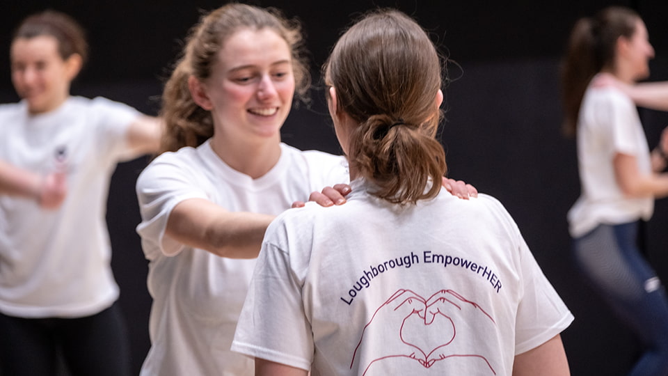 People dancing with the words 'EmpowerHER' in white