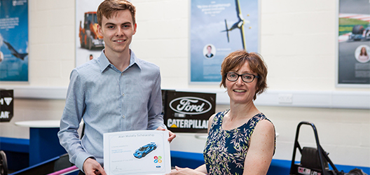 photo of student George Carter receiving certificate for Alan Mulally Scholarship from Angela Morley