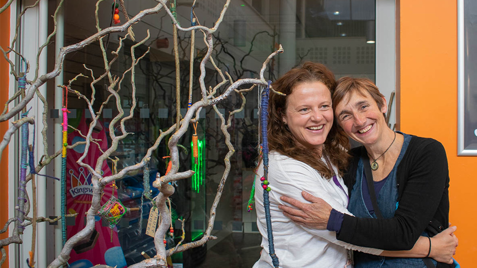 photo of artist Anne-Marie Culhane and Sustainability Manager Jo Shields hugging