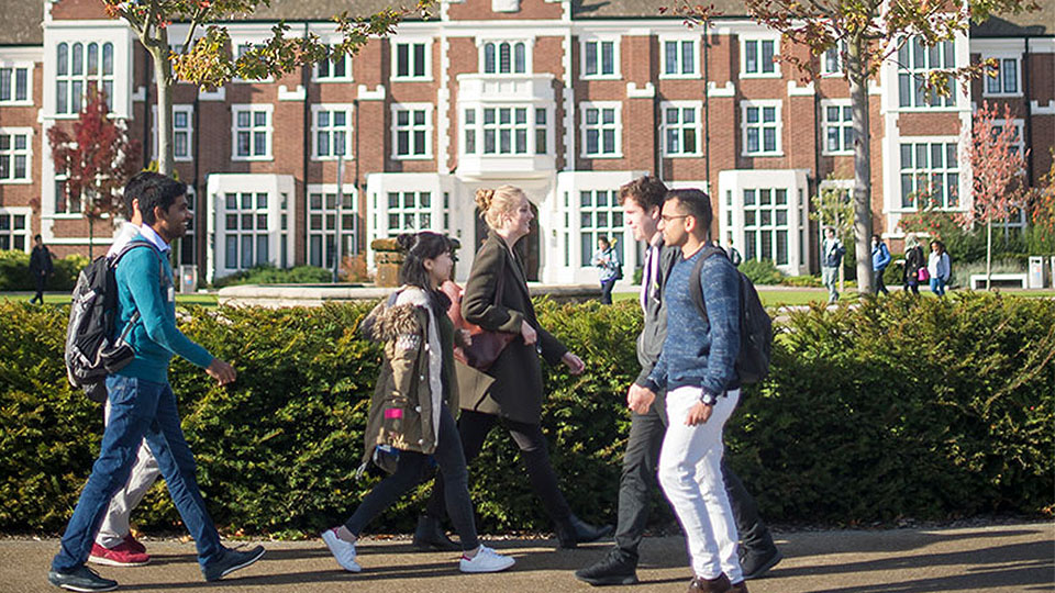 Photo of students walking along the pavement close to the Hazlerigg and Rutland lawn. 