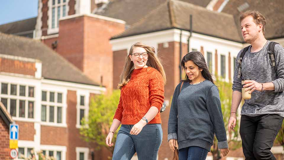 photo of three students walking on campus together