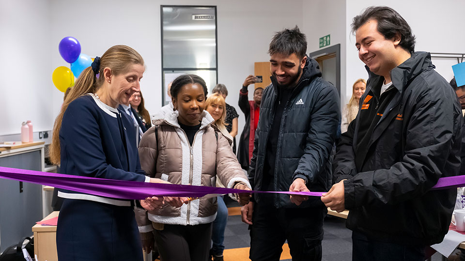 Professor Rachel Thomson with students cutting purple ribbon