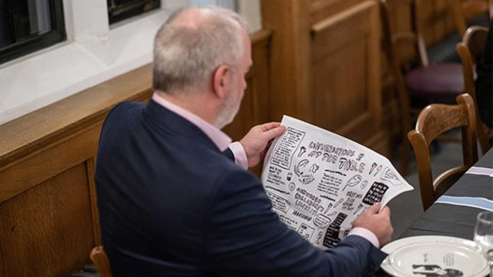 Photo of VC Nick Jennings reading the words inked onto the napkins at the event