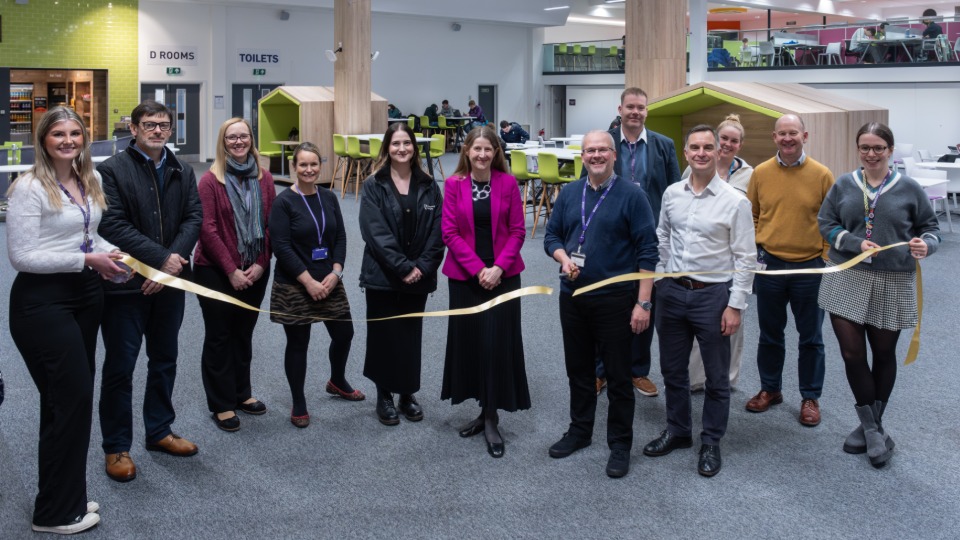 Loughborough University and LSU colleagues cutting a ribbon in James France Exhibition Area