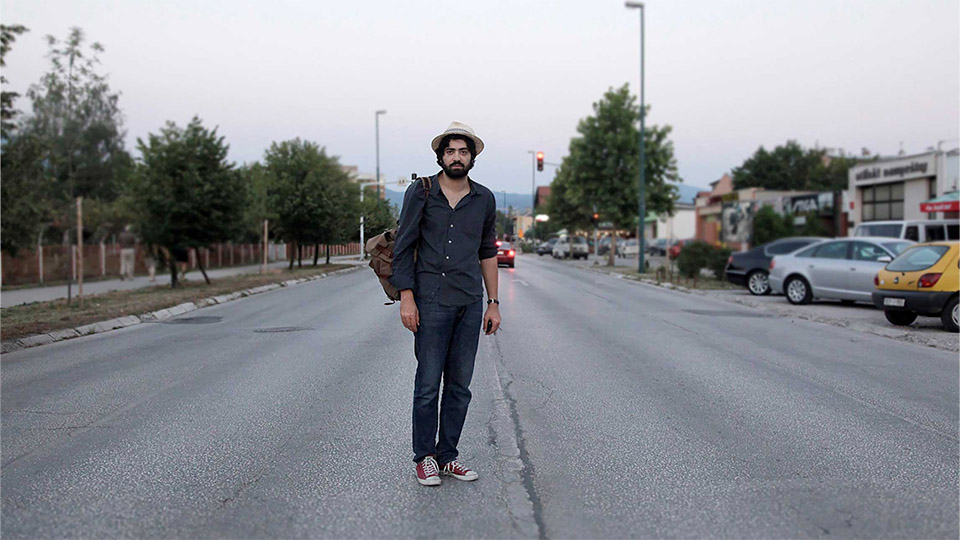 photo of a man stood in the middle of an empty road