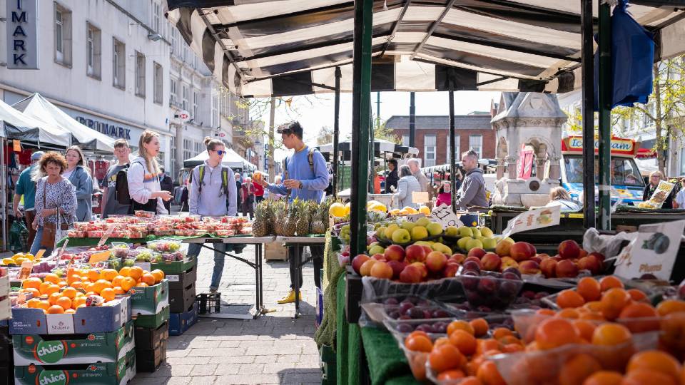 A group of students browsing fresh produce at Loughborough Market
