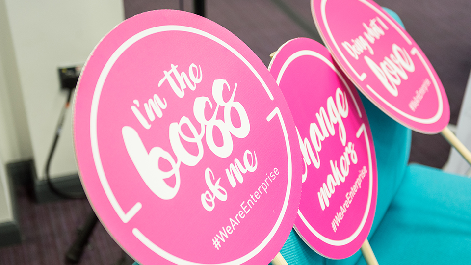 Photo of pink 'lollipop' signs with various white text on