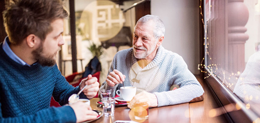 image of elderly man and another man talking in a cafe