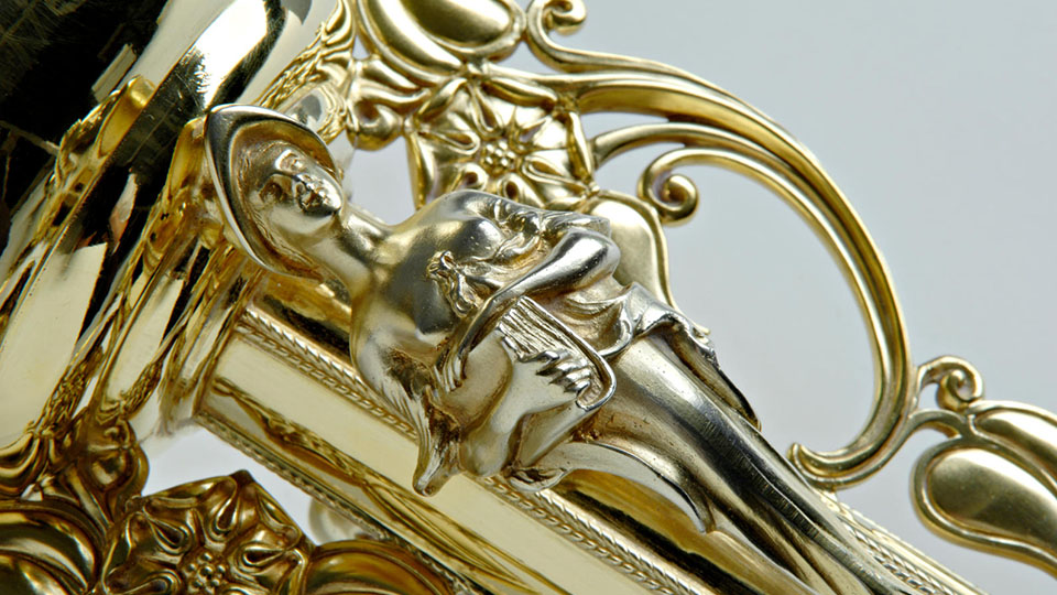 A close-up of the crown of the gold University Mace