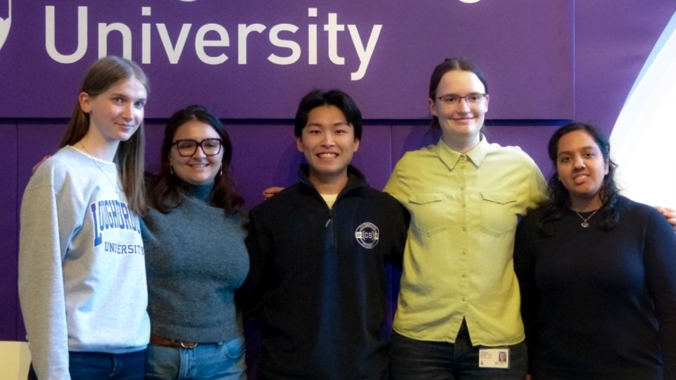 Five students standing together in front of a purple wall.