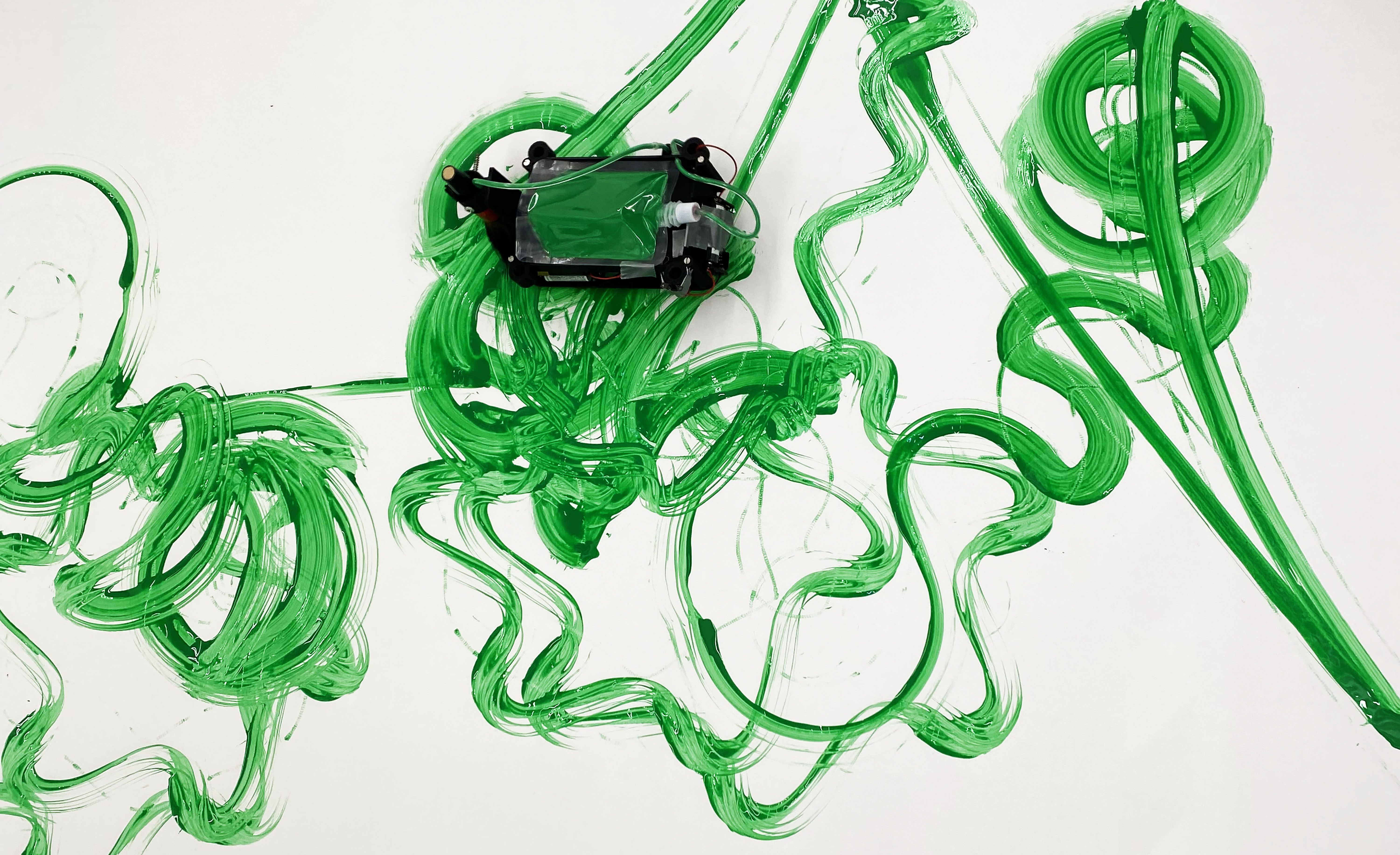 Robot painting green paint on a white canvas