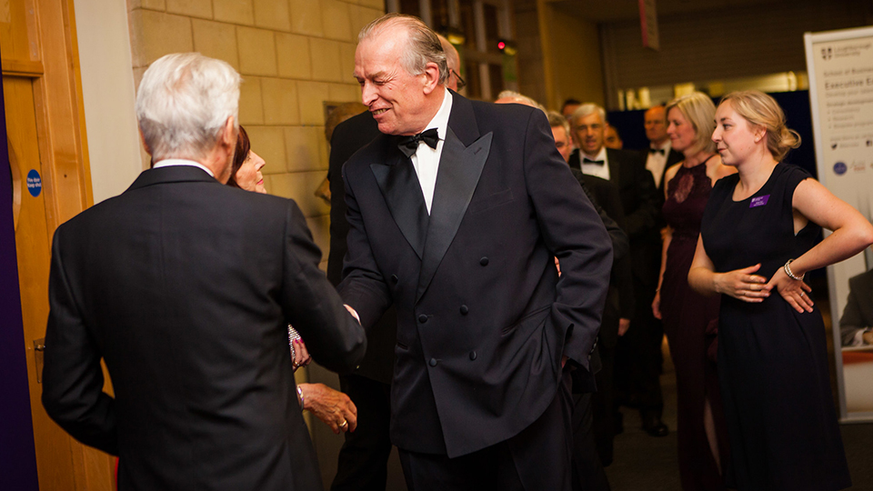 Photo of Paul Hodgkinson wearing a suit and shaking hands with someone