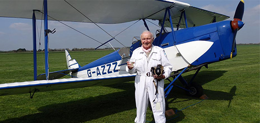 Pictured is Captain Desmond Penrose and a DH82a Tiger Moth.