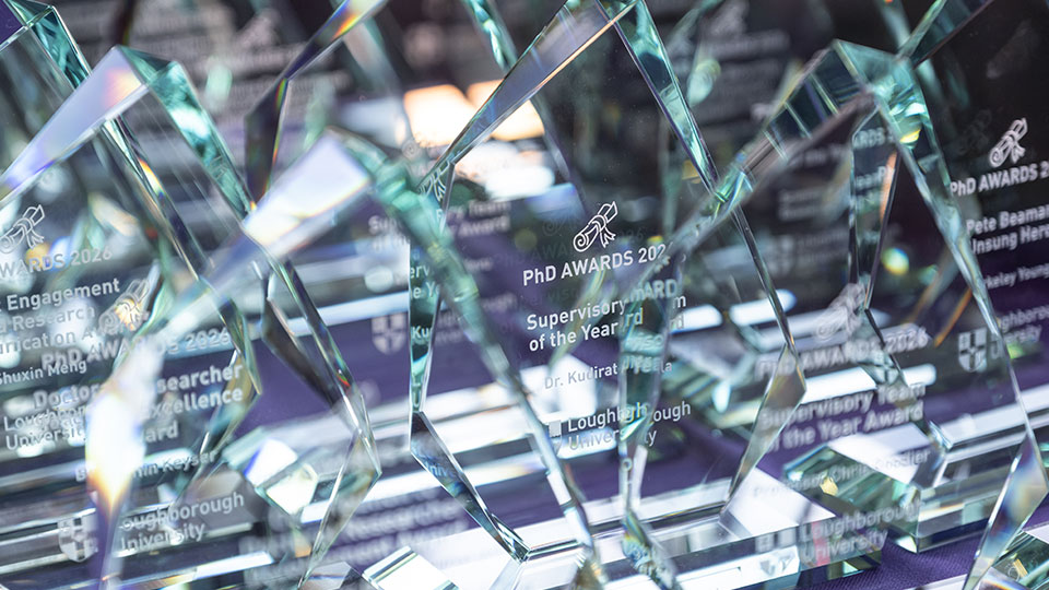 Rows of glass PhD Awards 2026 lined up on a table