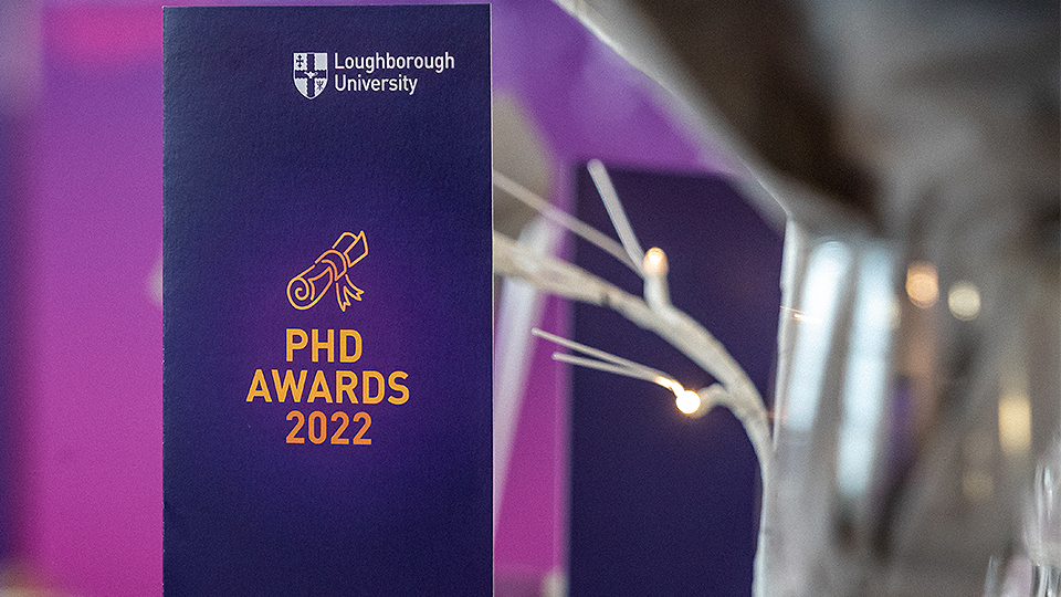 Close-up image of table talker on table that is purple and says 'PhD Awards' on it