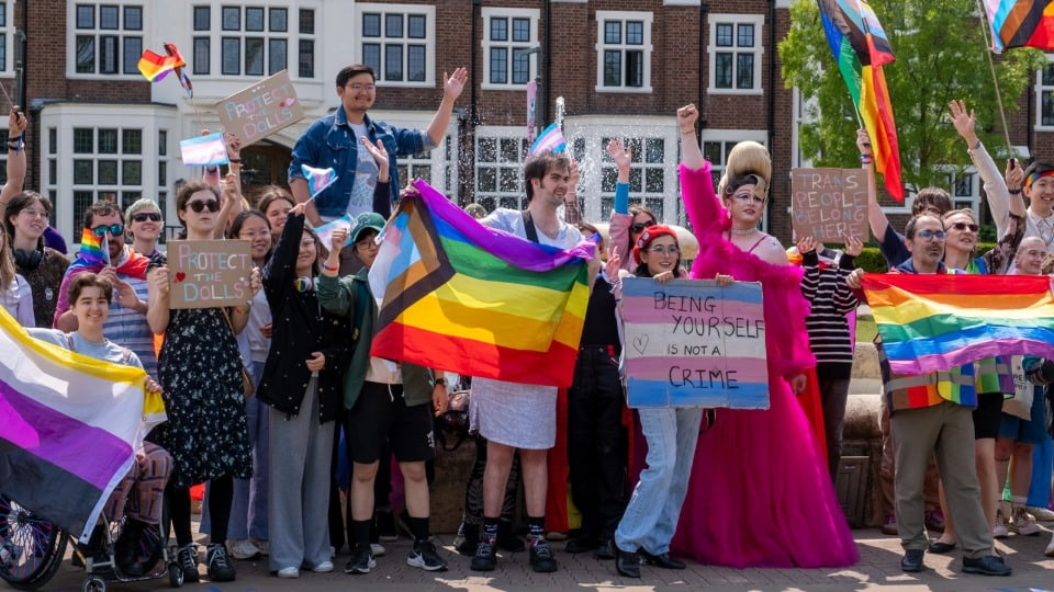 Students and staff outside Hazlerigg building celebratring Pride 2025 with signs and flags