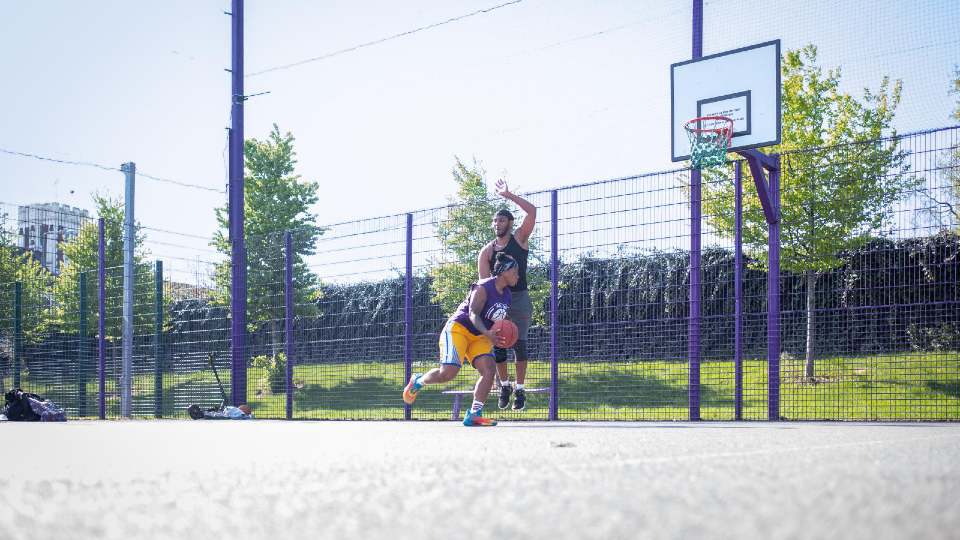 two people playing basketball on an outside court