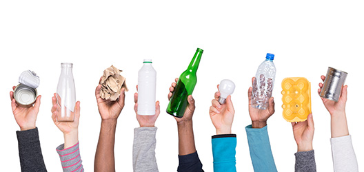 Pictured are people holding recyclable objects such as plastic bottles and egg cartons. 