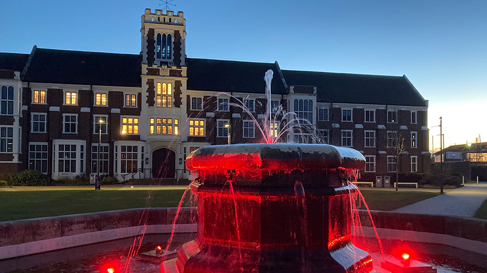 Photo of the fountain lit up red to raise awareness of World Encephalitis Day.