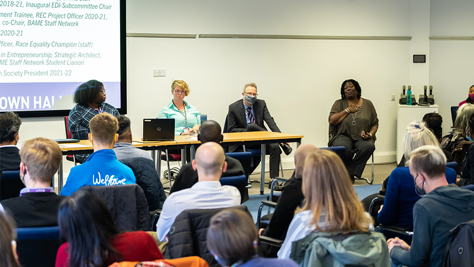 Photo of the panel (Tara Nadi, Emma Dresser, Richard Taylor and Veronica Moore) sat the front of the room at the Race Equity Town Hall event