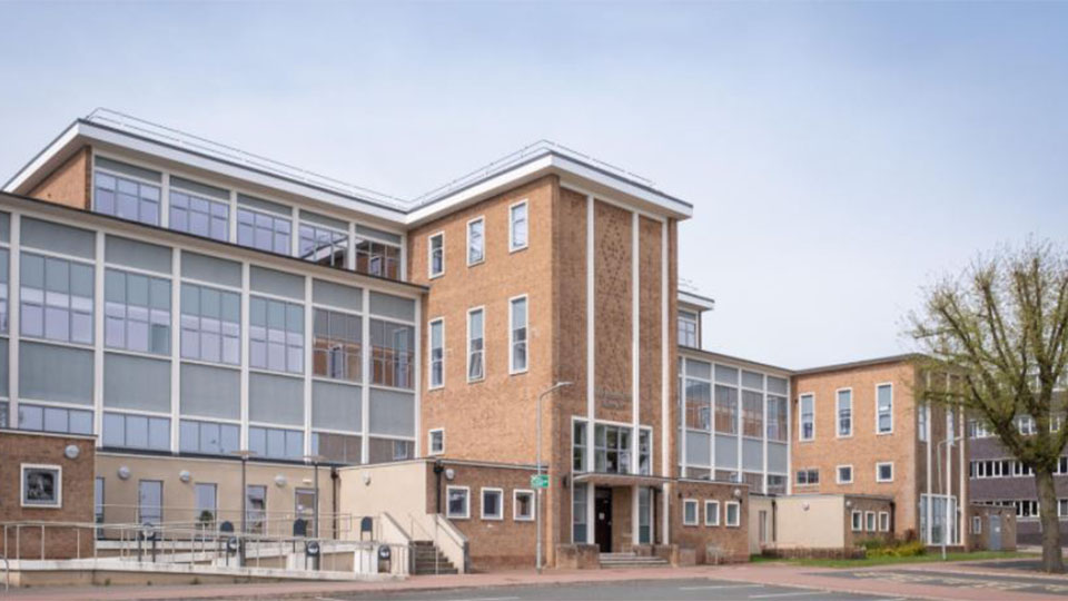 Photo of the exterior of Schofield Building and the car park in front of it