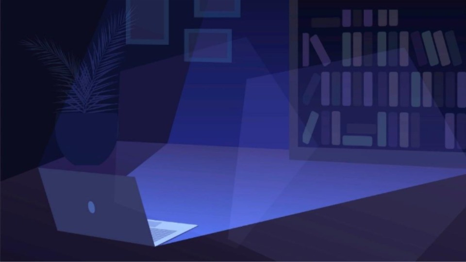 A laptop lightning up a dark room with blue light.