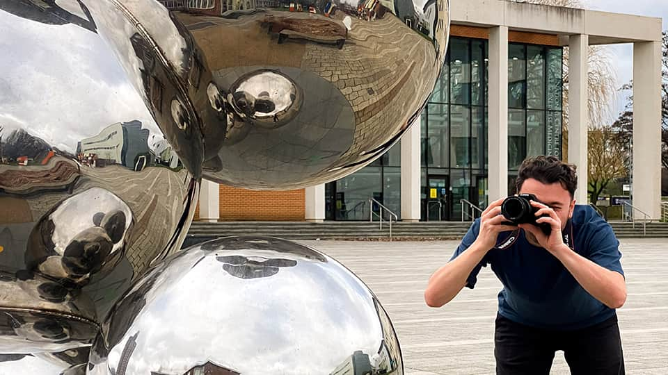 Man taking photograph of sculpture