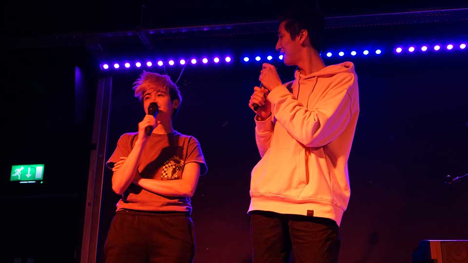 Two performers on stage holding microphones