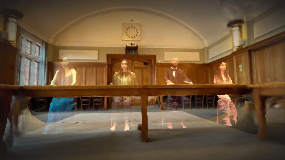 Four ghost-like figures sitting at wooden chairs behind a large wooden table in the Hazlerigg Council Chamber on Loughborough University campus.