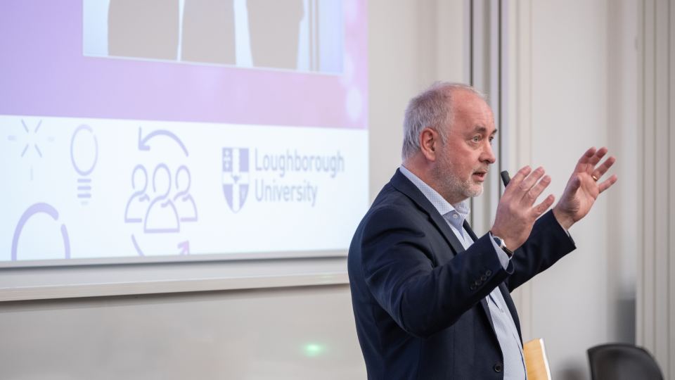 Vice Chancellor Professor Nick Jennings presenting to an audience in a lecture feature in front of a large screen