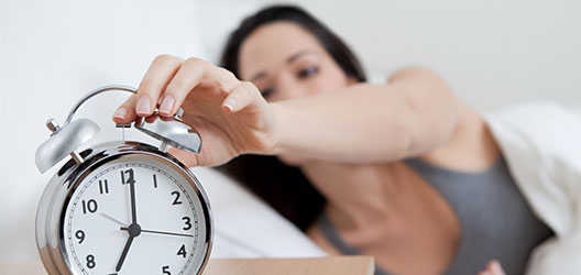 photo of a woman stopping her alarm clock 