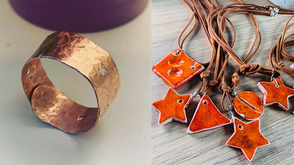 A brass ring propped up on its side and some orange necklaces with different shaped pendants