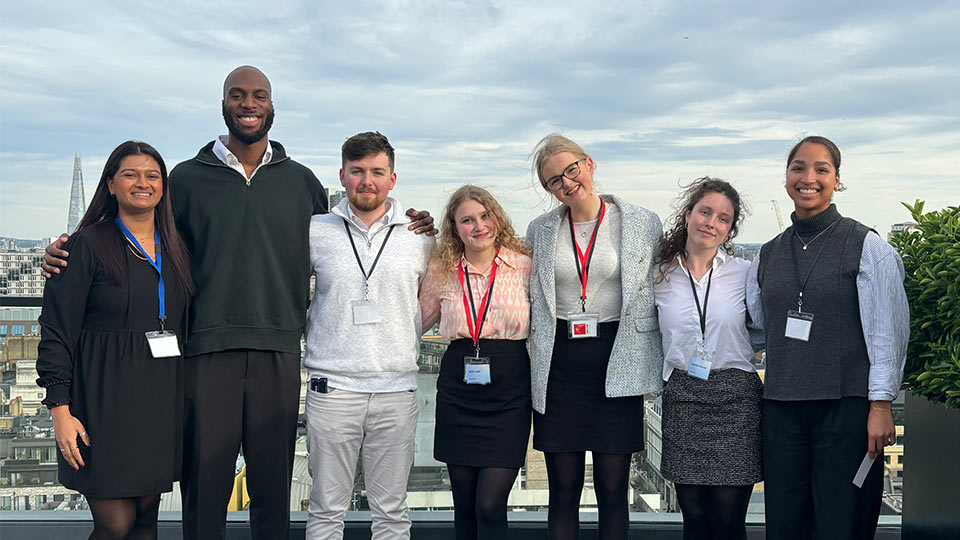 Samuel Ola with six other students standing on a rooftop terrace