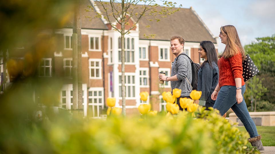 Students walking in front of Hazlerigg building on the Loughborough University campus